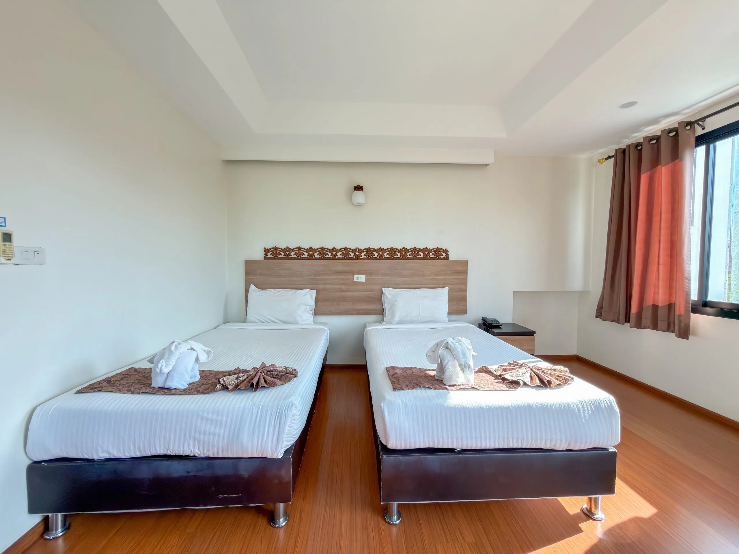 Superior Twin room: two single beds with a carved wooden headboard and towel elephants