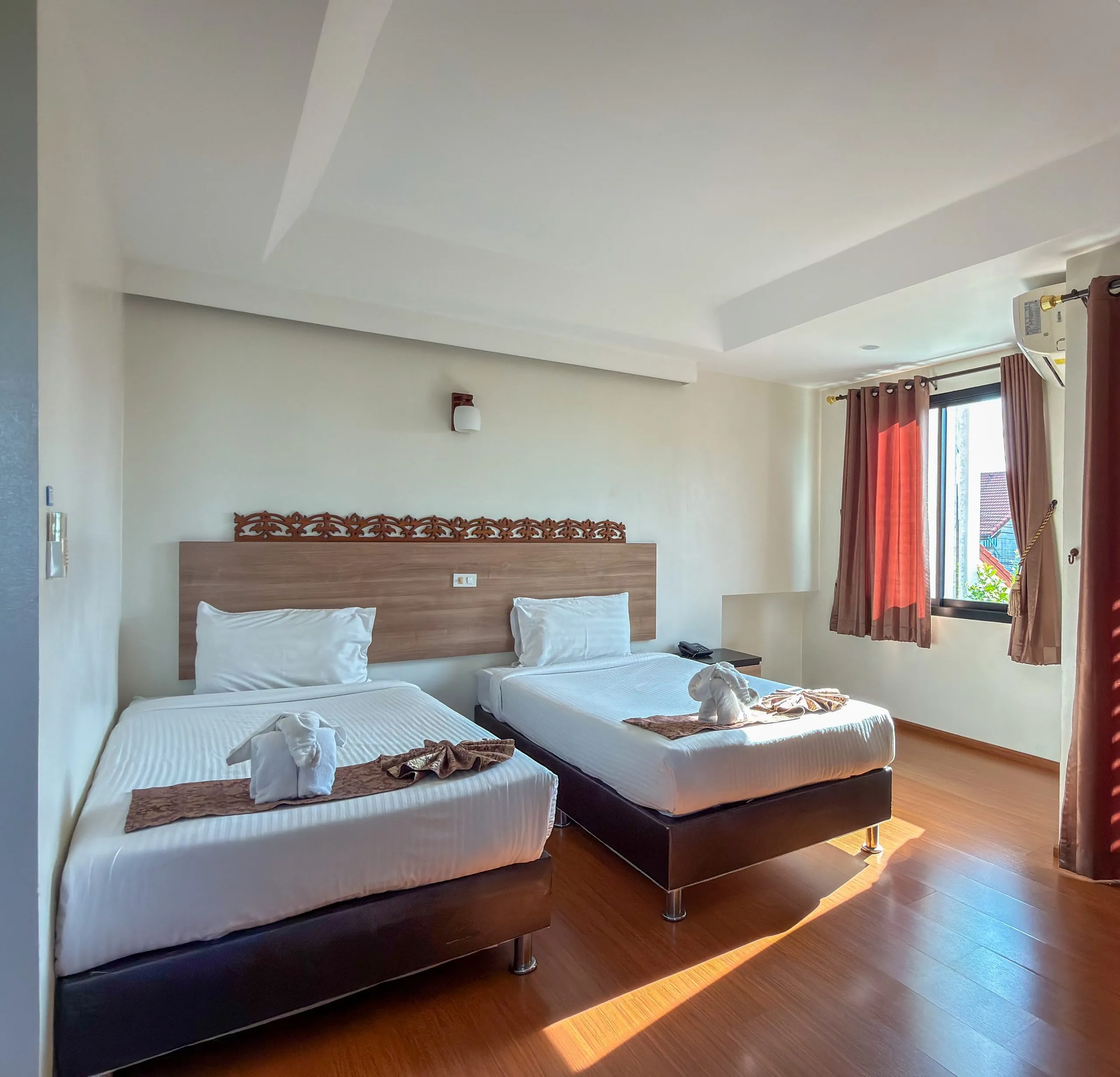 Superior Twin room: two single beds, window with curtains and wooden floor