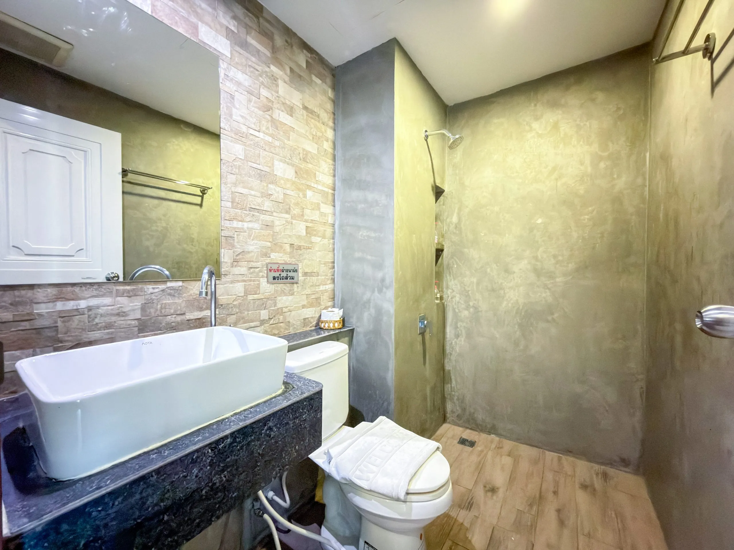 Standard Twin room bathroom: basin, toilet and walk-in shower with grey plaster walls