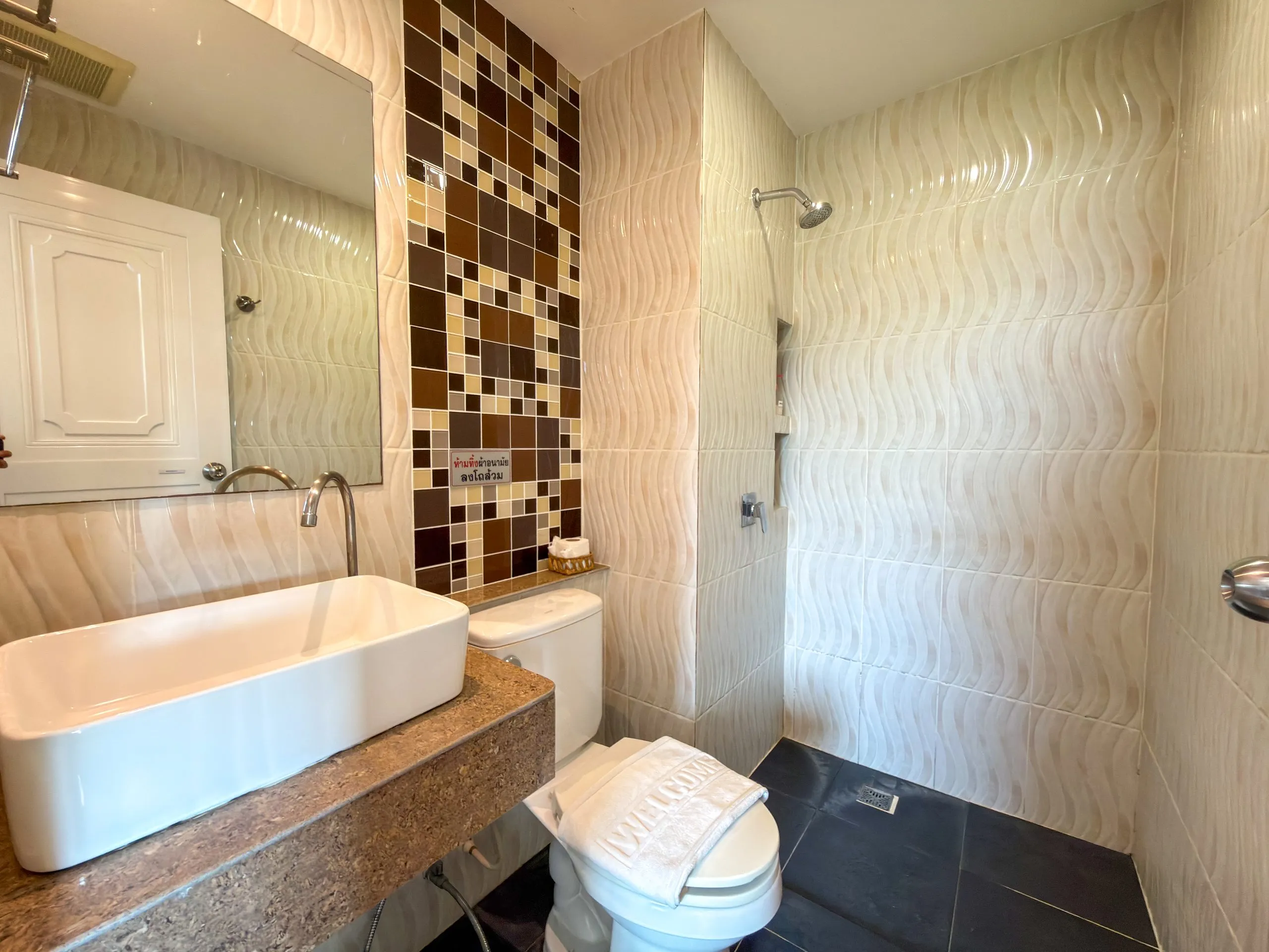 Superior Twin room bathroom: basin, toilet and walk-in shower with wave-pattern tiles
