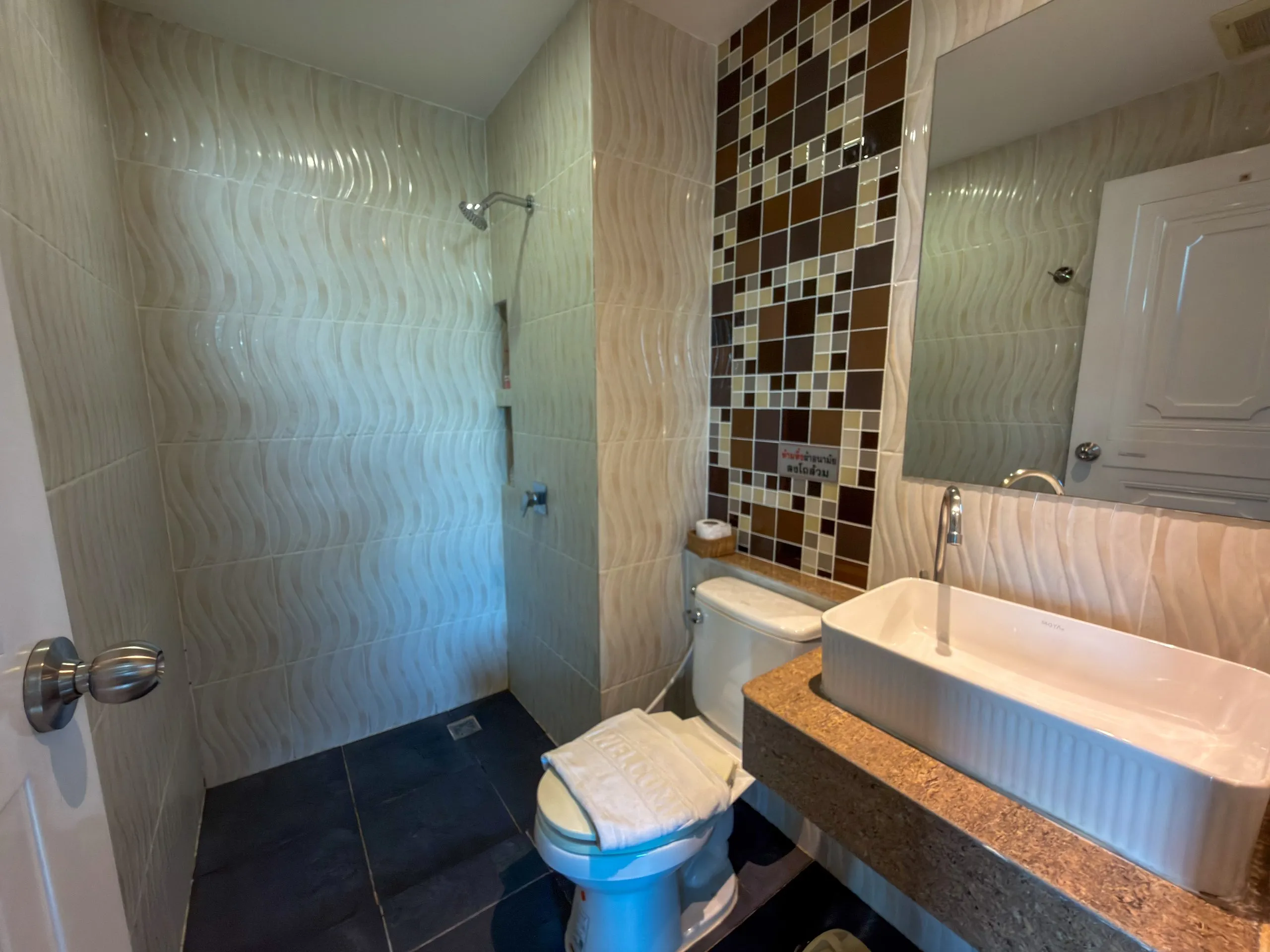 Superior King room bathroom: walk-in shower, toilet and basin with wave-pattern tiles