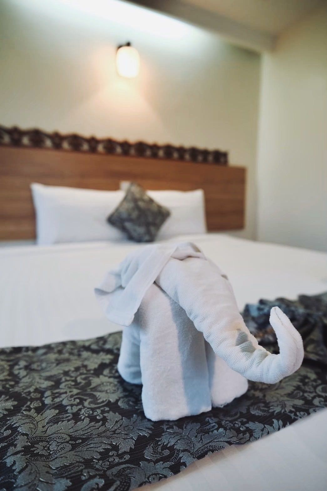 A towel folded into an elephant, close-up, on the bed